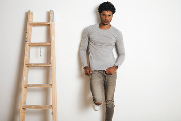 Sticker - Serious attractive latino man wears blank grey longsleeve and poses near ladder , isolated on white