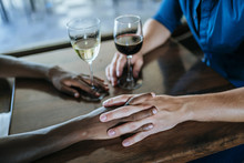 Close-up Of A Couple Holding Hands In Restaurant