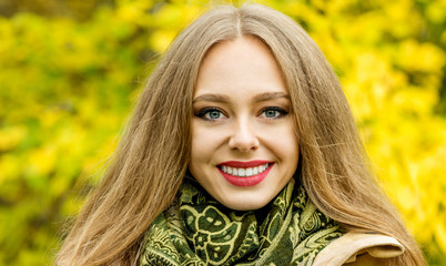 Beautiful elegant woman in autumn park. Fall yellow garden backg