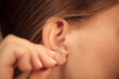 © Voyagerix - Woman cleaning ear with cotton swabs closeup