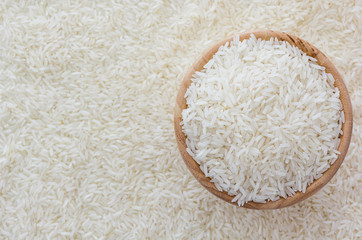 grains of Thai jasmine rice in wooden bowl on white rice background, top view with copy space, high resolution product.