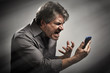 © grinny - Angry screaming man with cell phone.