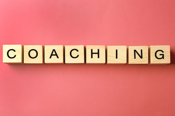 Wall Mural - Coaching concept. Wooden cubes on pink background