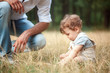 © master1305 - Young beautiful father and little toddler son against green grass