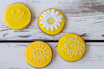 Top view of iced cookies. Round biscuits on wooden background. Flower and smiling sun. Art starts from imagination.