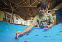 Man Making A Batik By Brushing Hot Wax On Cloth, Jember, East Java, Indonesia