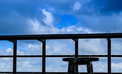 Wall Mural - metal balcony and metal chair with sky background