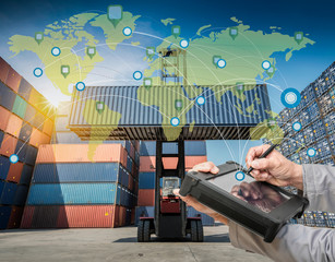 Wall Mural - Hand presses on world map with digital tablet,Industrial Container Cargo freight ship at dusk for Logistic Import Export background (Elements of this image furnished by NASA)