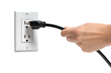 Woman's Hand Pulling Electrical Plug From Household Power Outlet Isolated On White Background