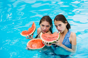 women with watermelon in swimming pool