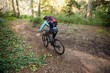 © WavebreakMediaMicro - Female mountain biker riding bicycle in the forest