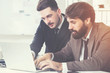 © ImageFlow - Bearded businesspeople discussing project