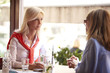 © sepy - Girlfriends at coffee shop. Shot of two pretty women sitting together at a table in a coffee house and gossiping.