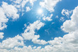 © yotrakbutda - Blue sky with clouds and sun reflection. looking up view