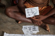 A farmer shows a record card representing money, Jharkhand, India