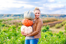 Beautiful Woman With Three Huge Pumpkins On Farm 