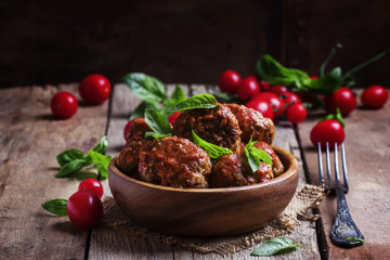 Meatballs of pork and beef with spicy tomato sauce in bowl, vint