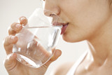 Fototapeta Łazienka - Young woman drinking  glass of water