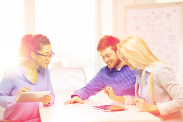 Wall Mural - smiling team with table pc and papers working