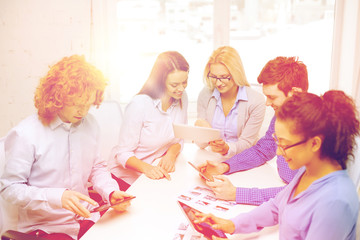 Canvas Print - smiling team with table pc and papers working