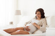 © Syda Productions - happy pregnant woman lying on bed at home