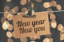 New Year New You Sign Pegged To A String With Blurred Bokeh Lights In The Background