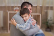 Sad son hugging his dad indoor