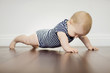 © Cavan Images - Baby boy exercising on floor at home