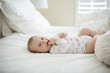 © Cavan Images - Cheerful baby boy lying on bed at home