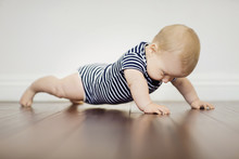 Baby Boy Exercising On Floor At Home