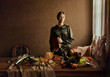 © AndrewLili - Woman wearing green clothing with still life of food and drink
