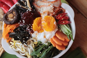 Wall Mural - Bibimbap korean food is delicious on wood background.