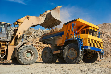 Wall Mural - Wheel loader loading ore into dump truck at opencast