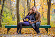 © Traida - Happy pregnant family walking in autumn Park