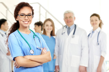 Wall Mural - Young doctor and medical team on blurred hospital background. Health care concept.