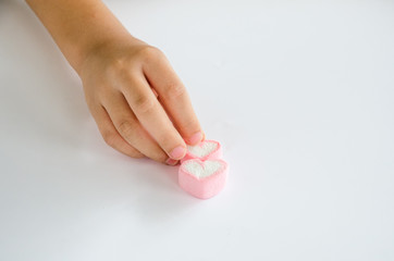 Child hands play jellys on white table