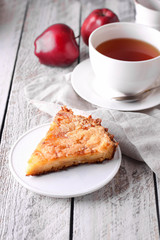 Wall Mural - Slice of homemade apple pie on a wooden background. Autumn breakfast with fruit pie and tea.