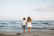 © Westend61 - Back view of little boy and girl standing side by side at seashore