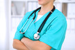 © rogerphoto - Female surgeon doctor is standing with arms crossed at hospital.  Physician  is ready to examine patient
