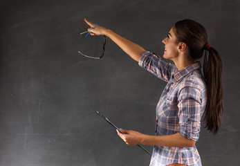 Young pretty female teacher writing on the chalkboard,copy space