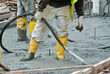 Construction workers using a concrete vibrator at the construction site to compact concrete slurry that pour in the form work. 