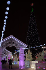 Wall Mural - Illuminated with colored lights and ice town Christmas tree.