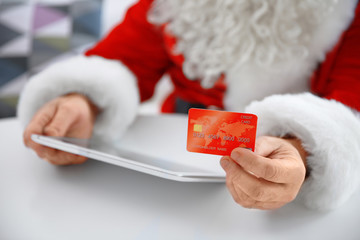 Canvas Print - Santa Claus with credit card and tablet at home, closeup