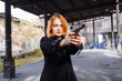 Woman pointing a gun. Mafia girl shooting at someone on the street. Emotion of fear, fright
