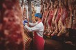 © Wavebreak Media - Butcher hanging red meat in storage room