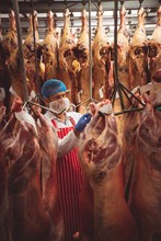 Butcher Sticking Barcode Stickers On Red Meat In Storage Room