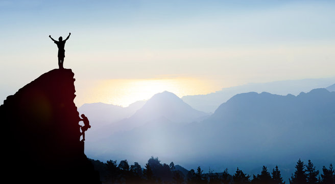 Fototapete - Bergsteiger auf einem Gipfel im Gebirge bei Sonnenaufgang