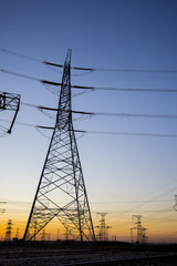 The silhouette of the evening electricity transmission pylon