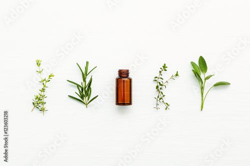 Fotografía Bottle of essential oil with fresh herbal sage, rosemary, lemon