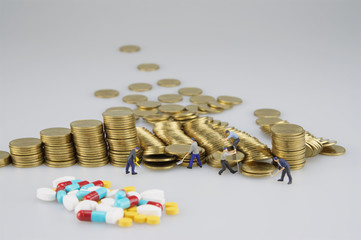 Wall Mural - Stack of gold coin with miniature people and blur medicine